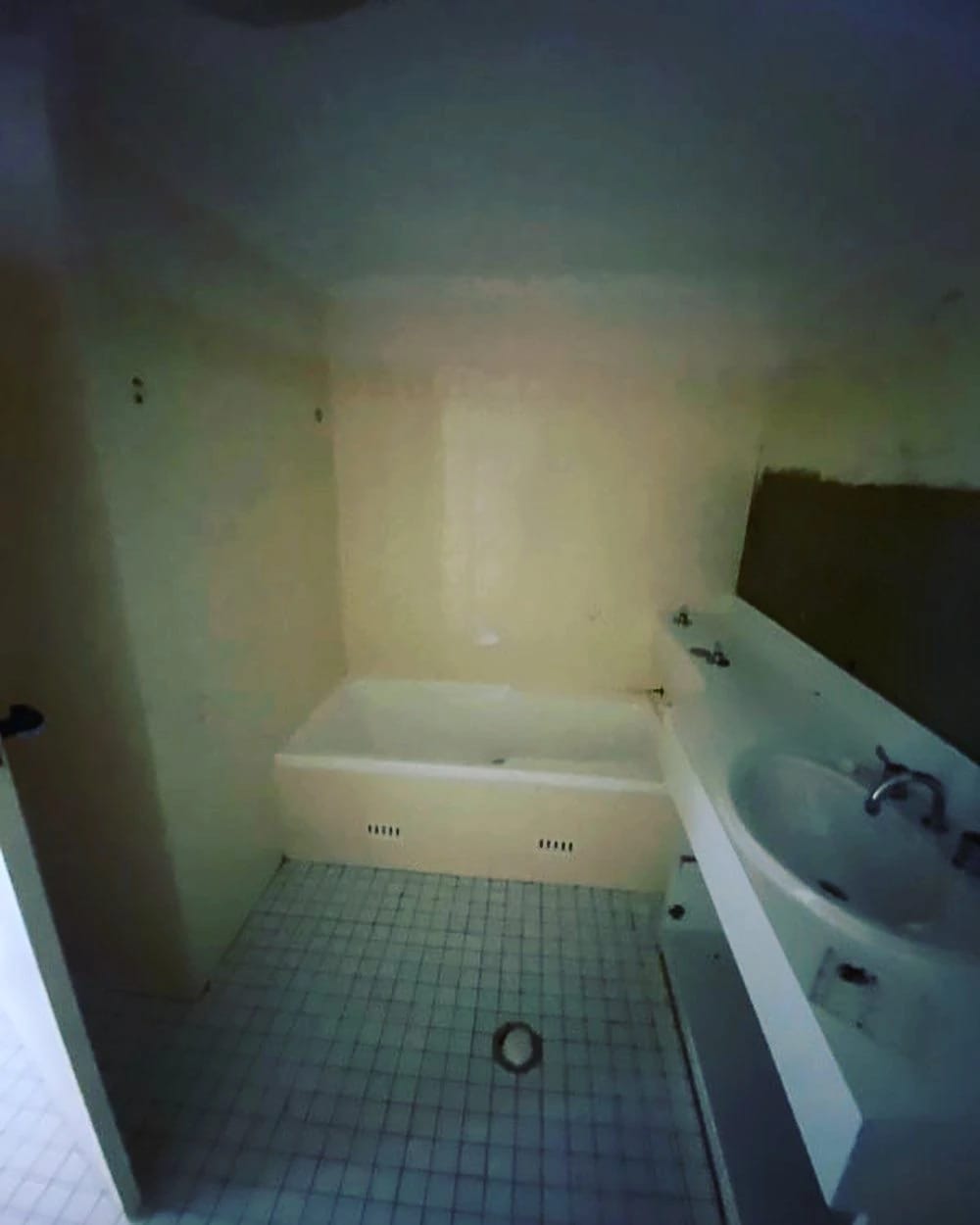 Bathroom with bath, vanity and tiled floor before strip out