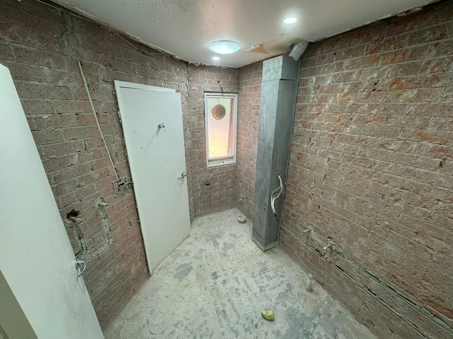 Same compact bathroom after fixtures and wall finishes were removed