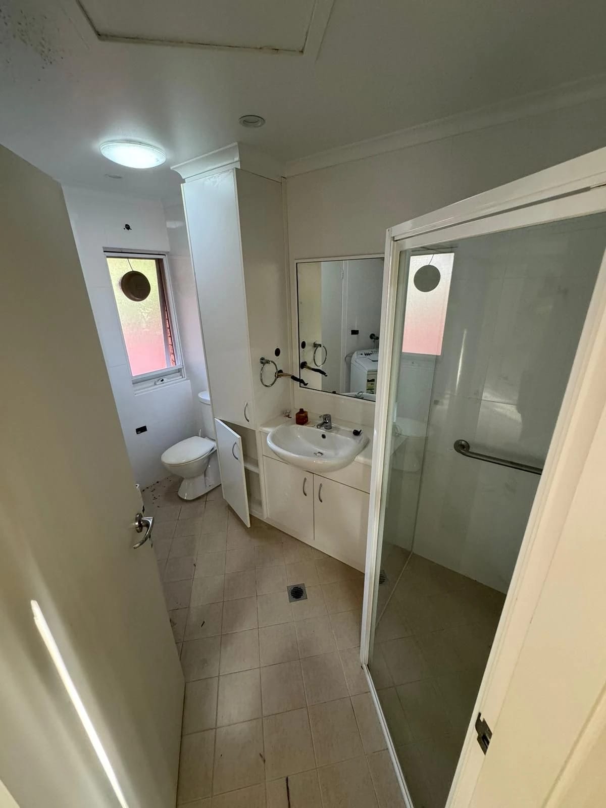 Compact bathroom with shower, vanity and tiled finishes before strip out