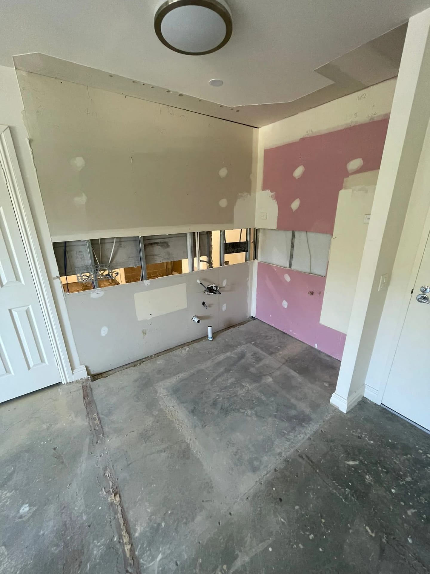 Same corner kitchen after cabinetry, appliances and wall finishes were removed