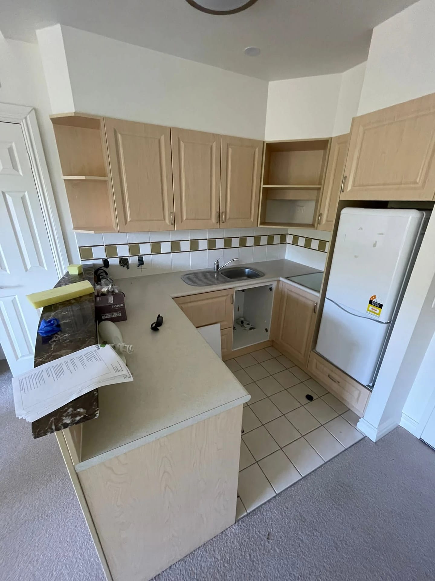 Corner kitchen with fitted cabinetry and appliances before strip out