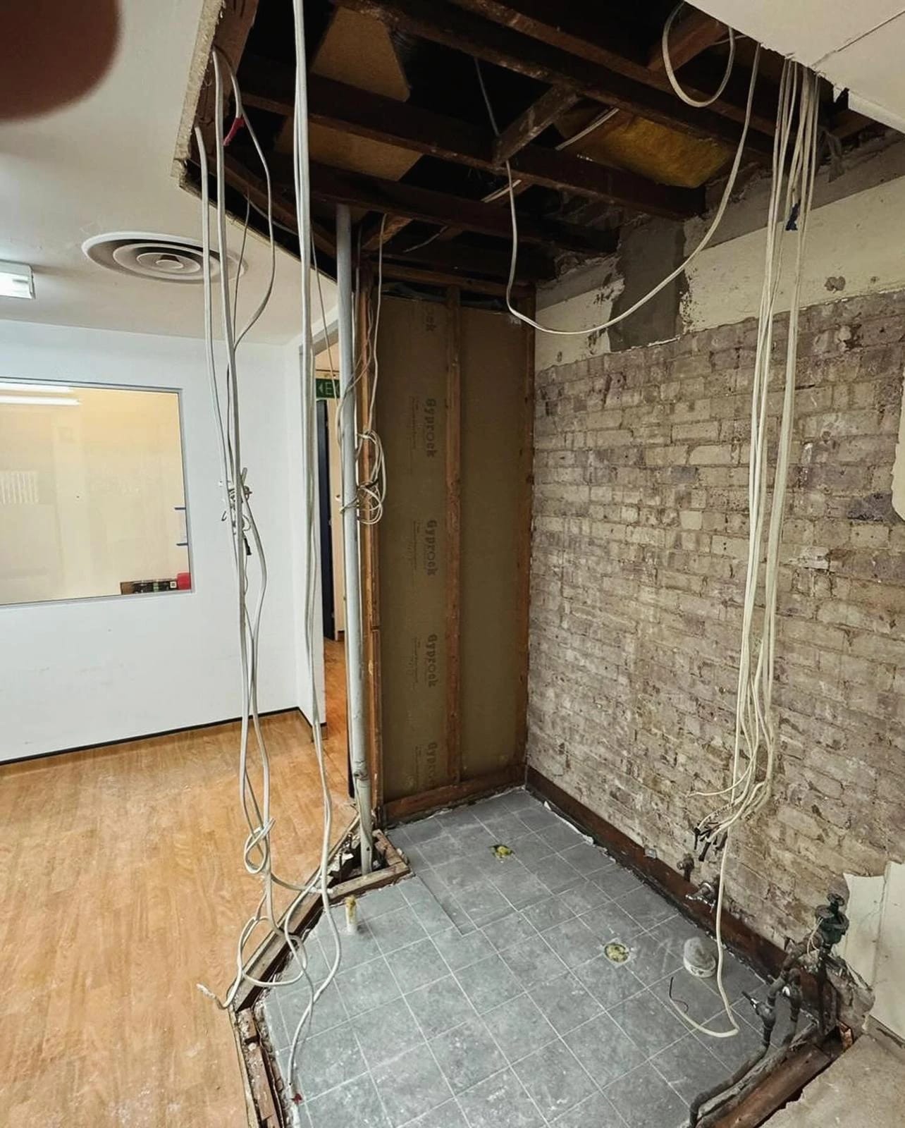Same bathroom after fixtures, tiles, ceiling and wall linings were removed