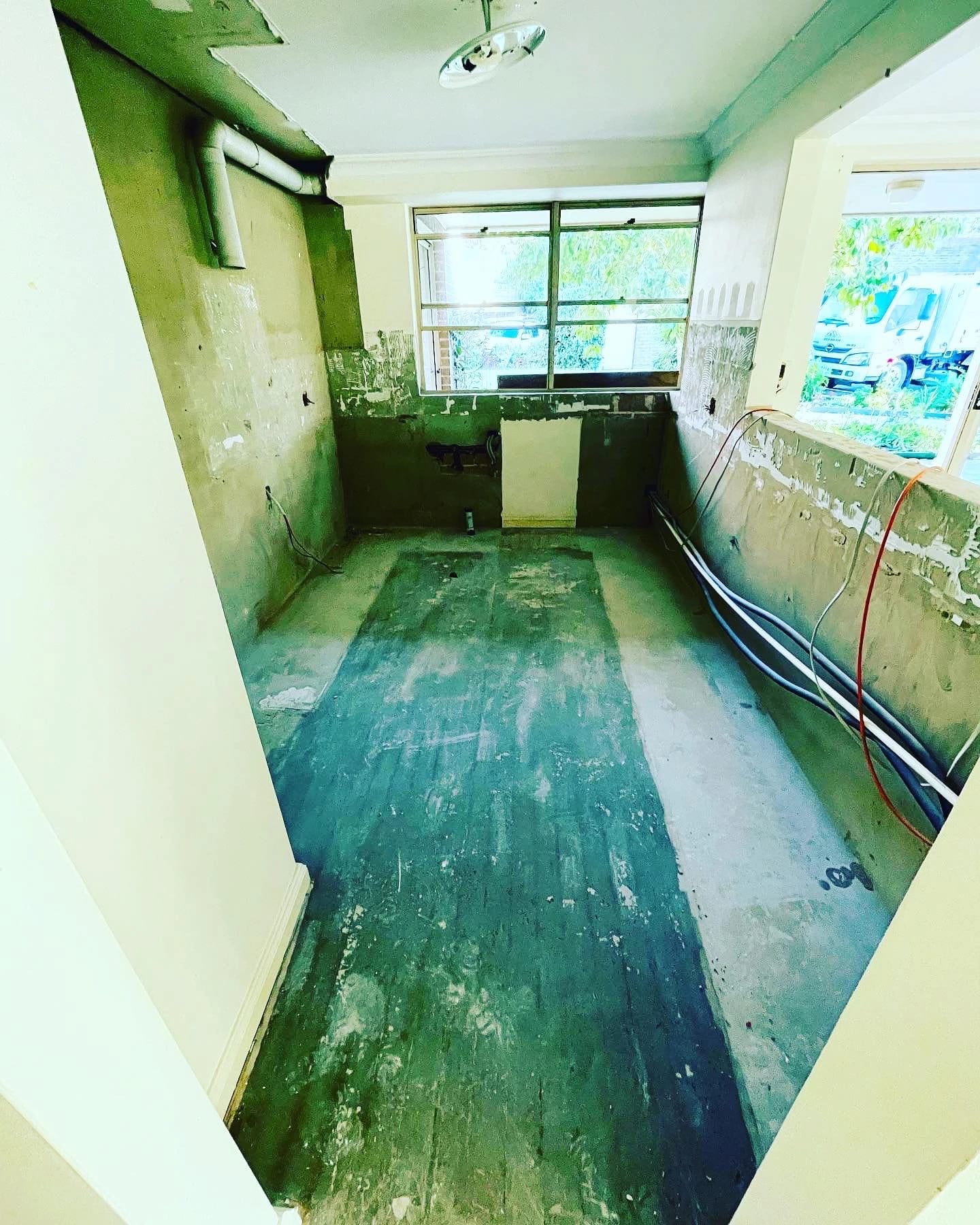 Same galley kitchen after cabinetry, appliances and floor finishes were removed