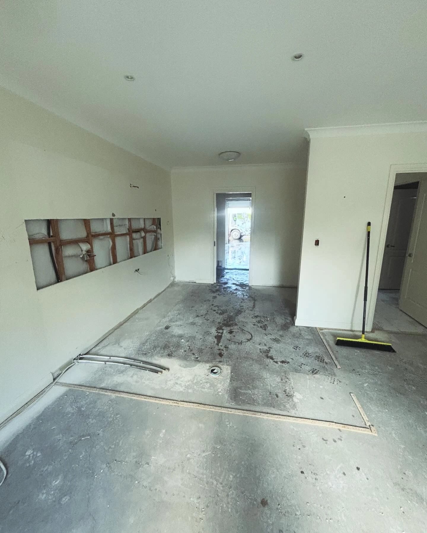 Same open-plan area after cabinetry, appliances and floor finishes were removed