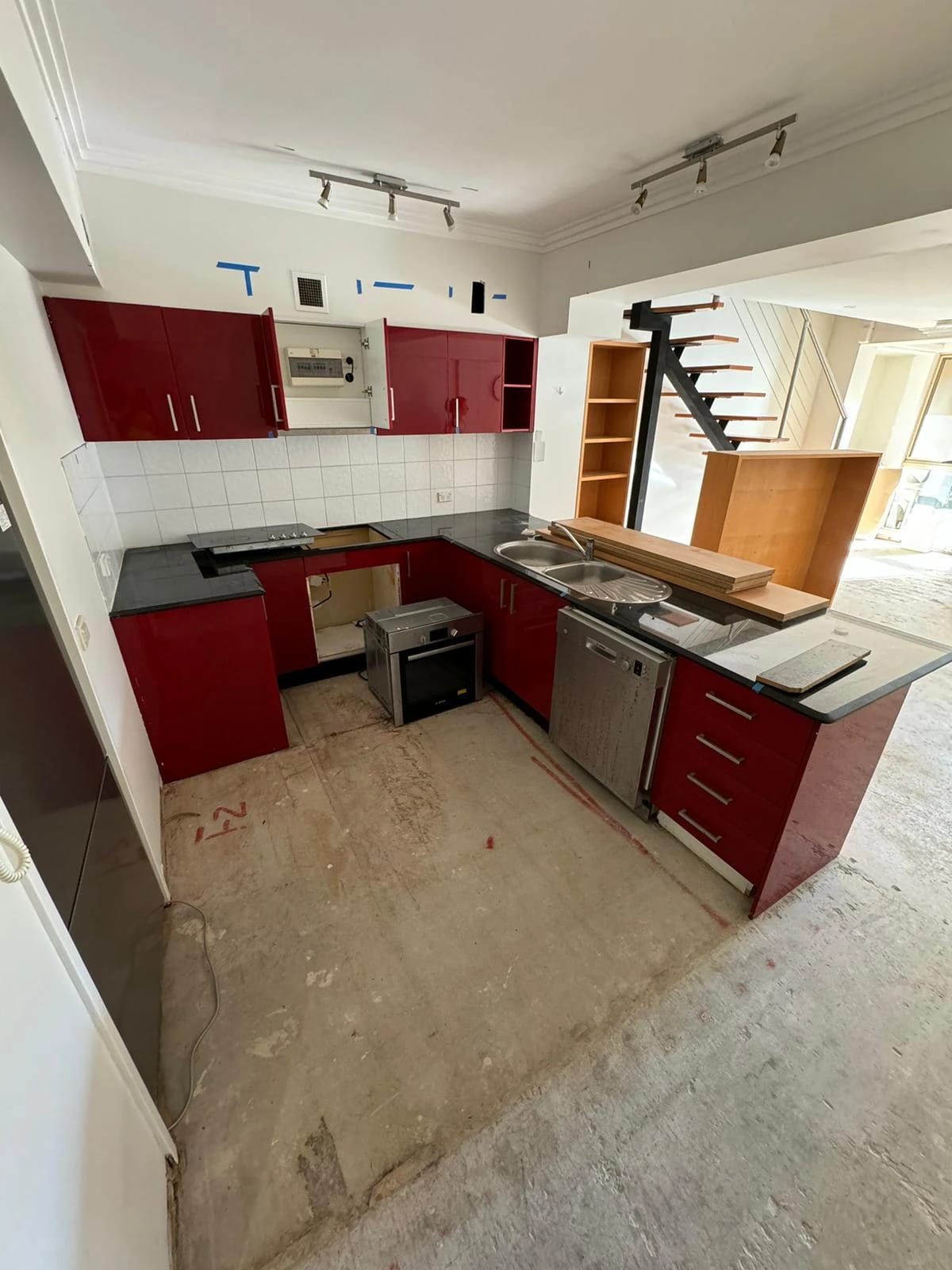 Red-cabinet kitchen with fitted appliances before strip out