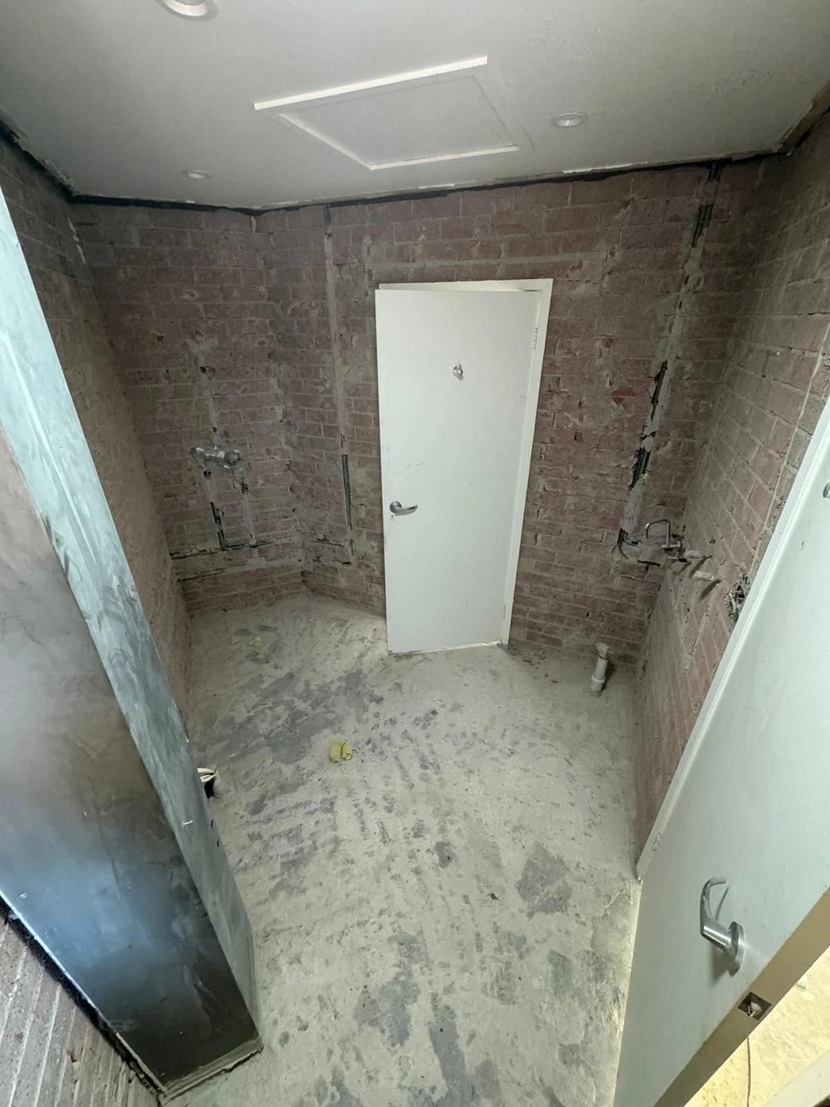 Same bathroom after the fixtures and wall finishes were removed