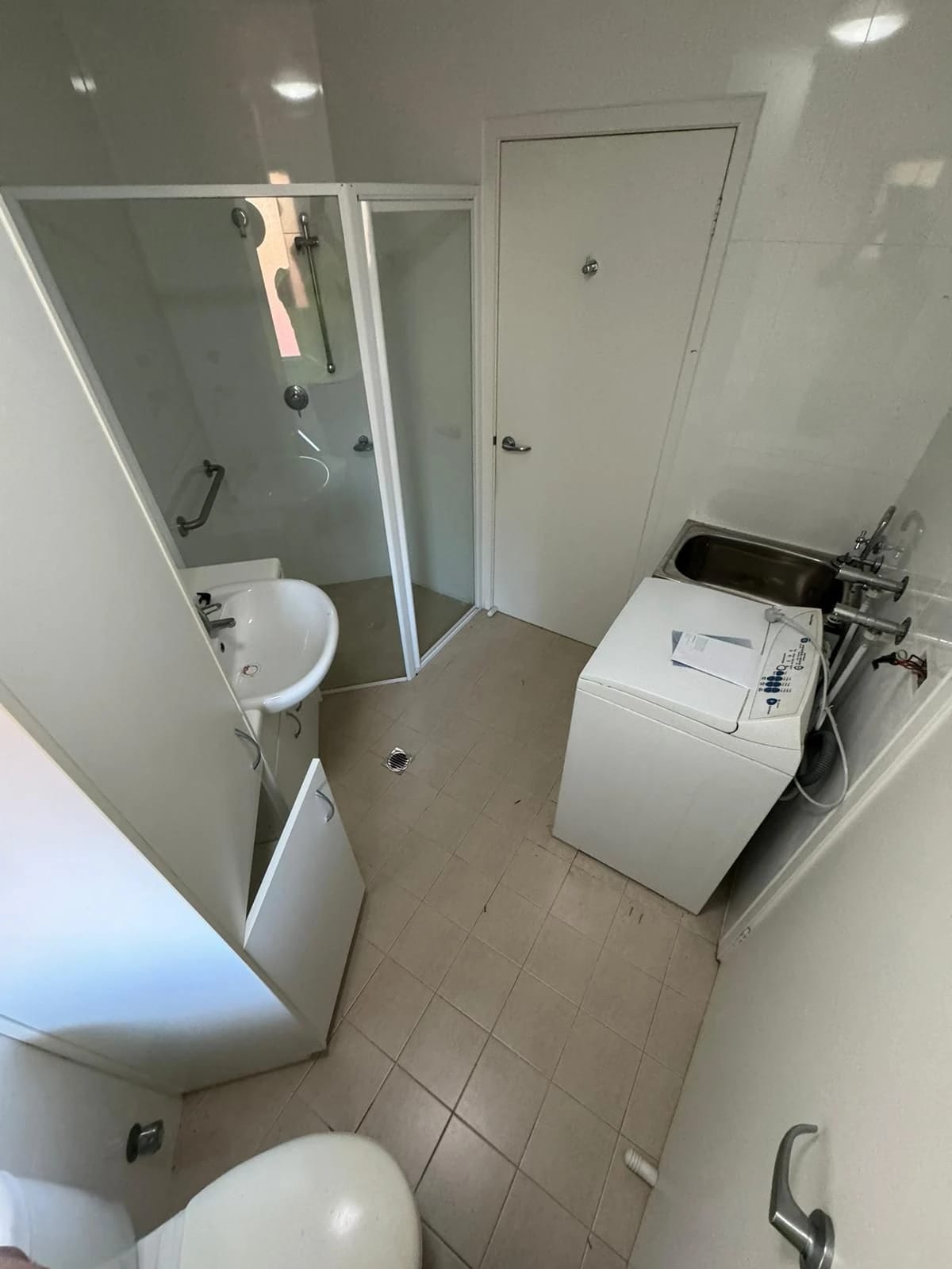 Bathroom with shower, vanity and tiled floor before strip out