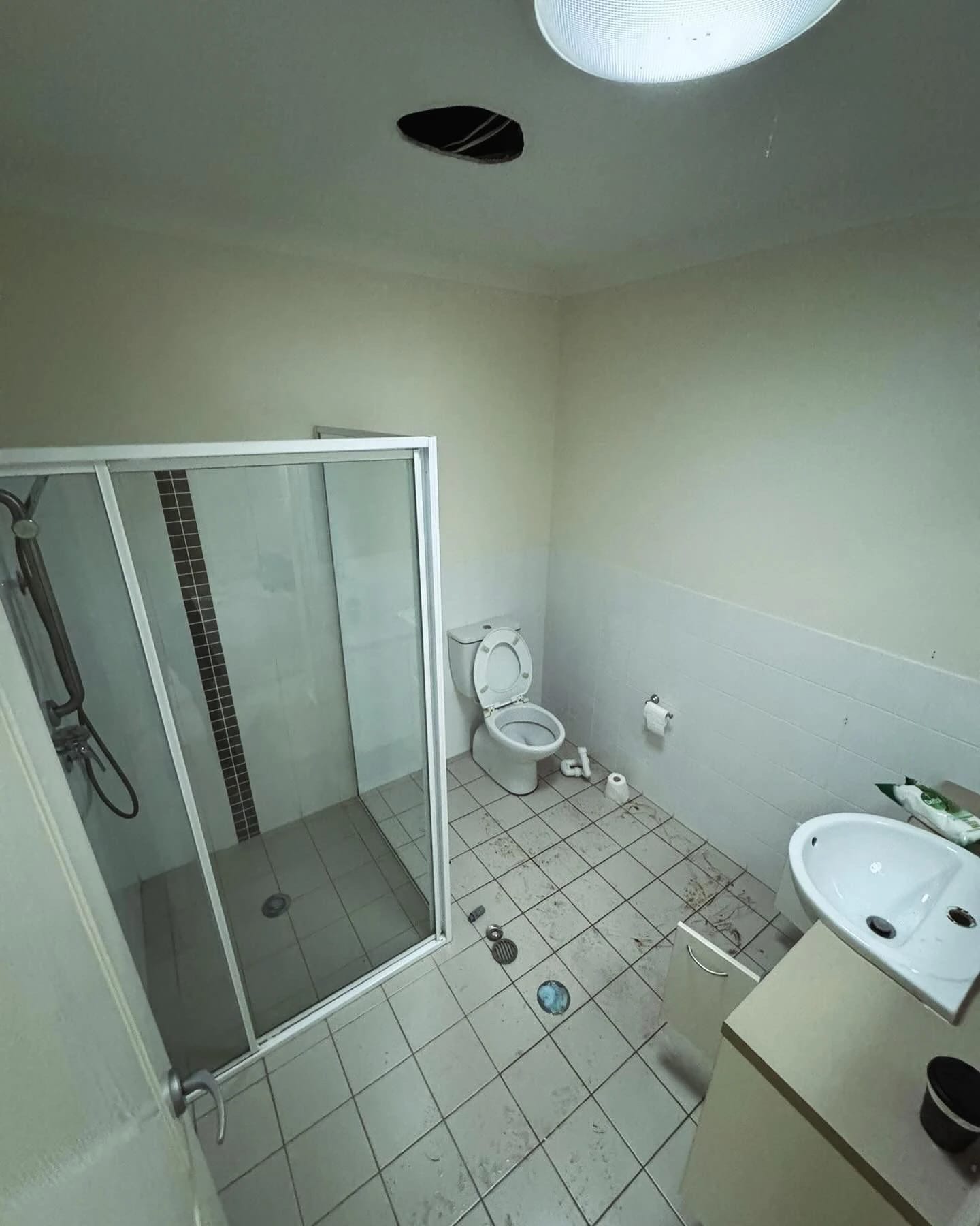 Bathroom with corner shower, vanity and toilet before strip out