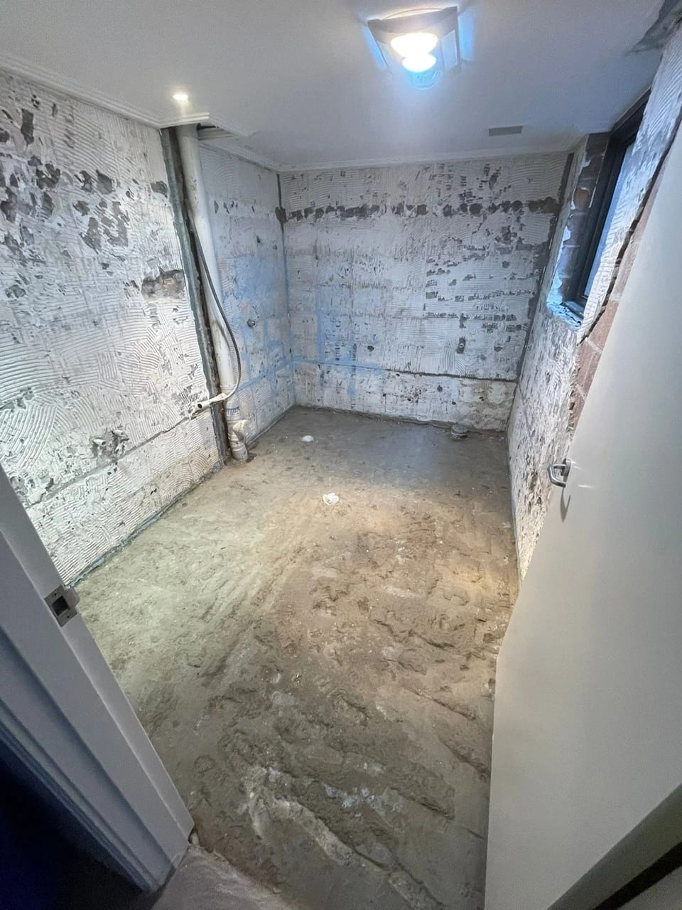 Same bathroom after fixtures, tiles and wall finishes were removed