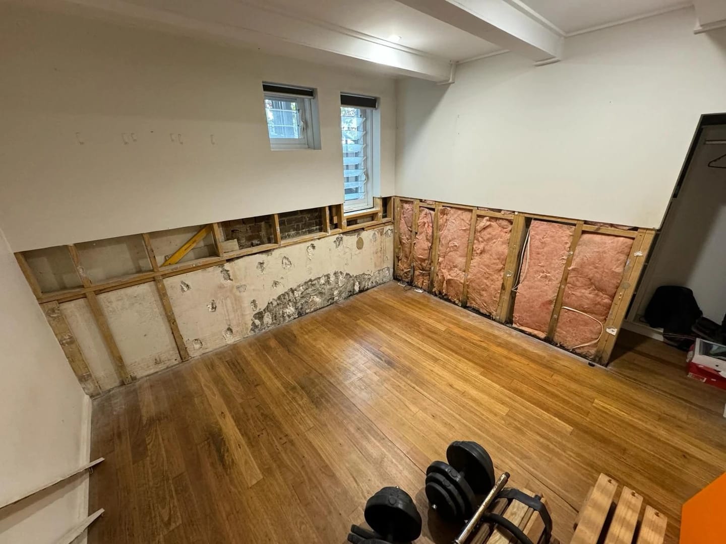 Same room after lower wall linings were removed to expose the framing