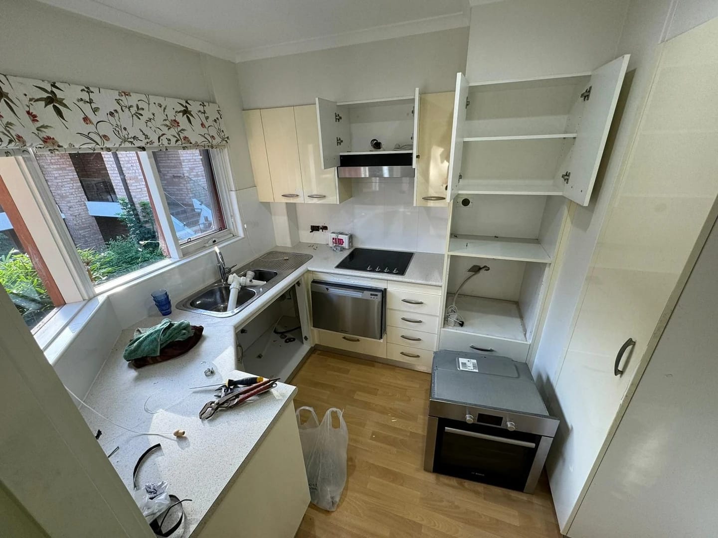 Window-side kitchen with cabinetry and appliances before strip out