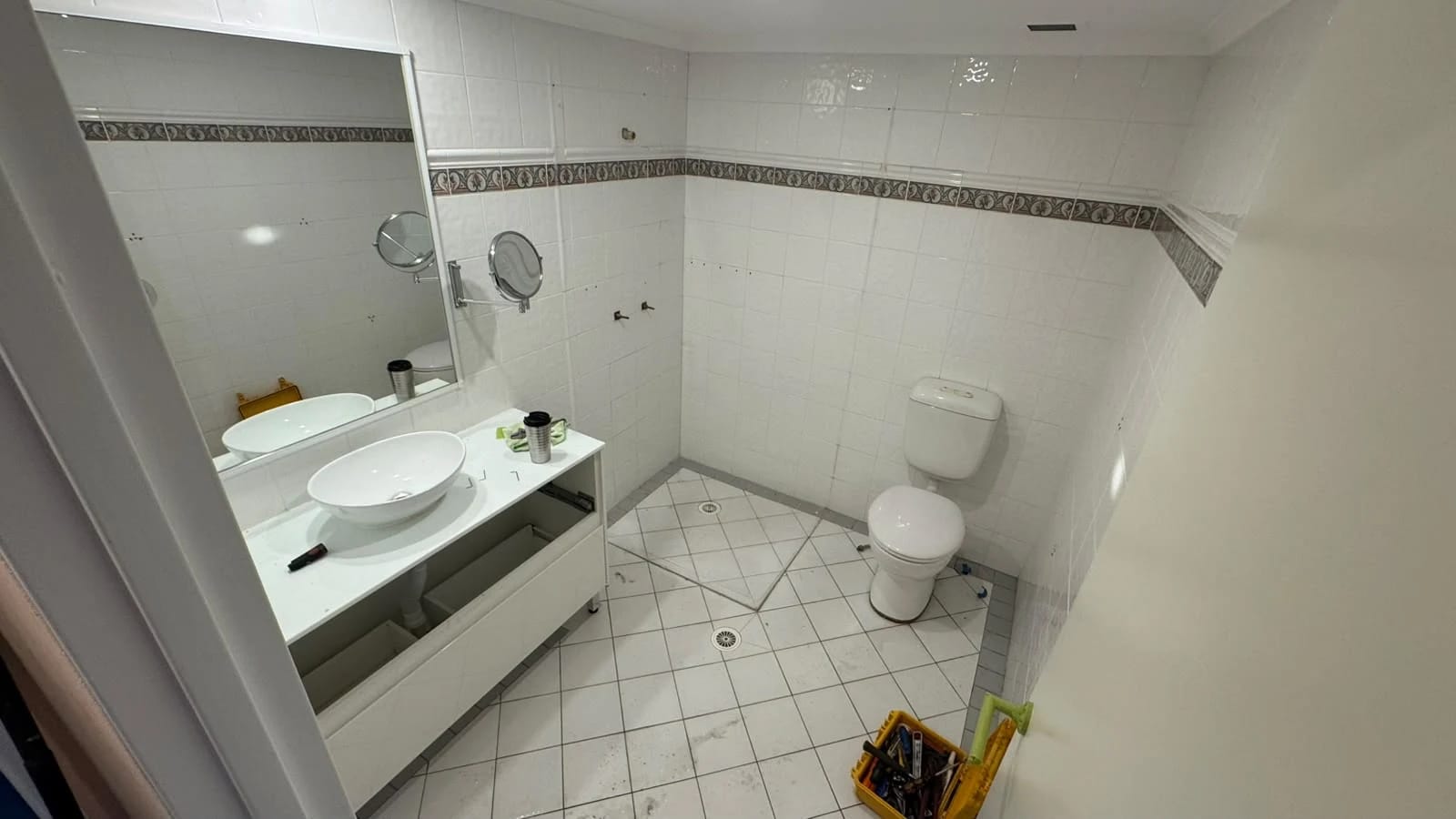 Tiled bathroom with vanity, basin, mirror and toilet