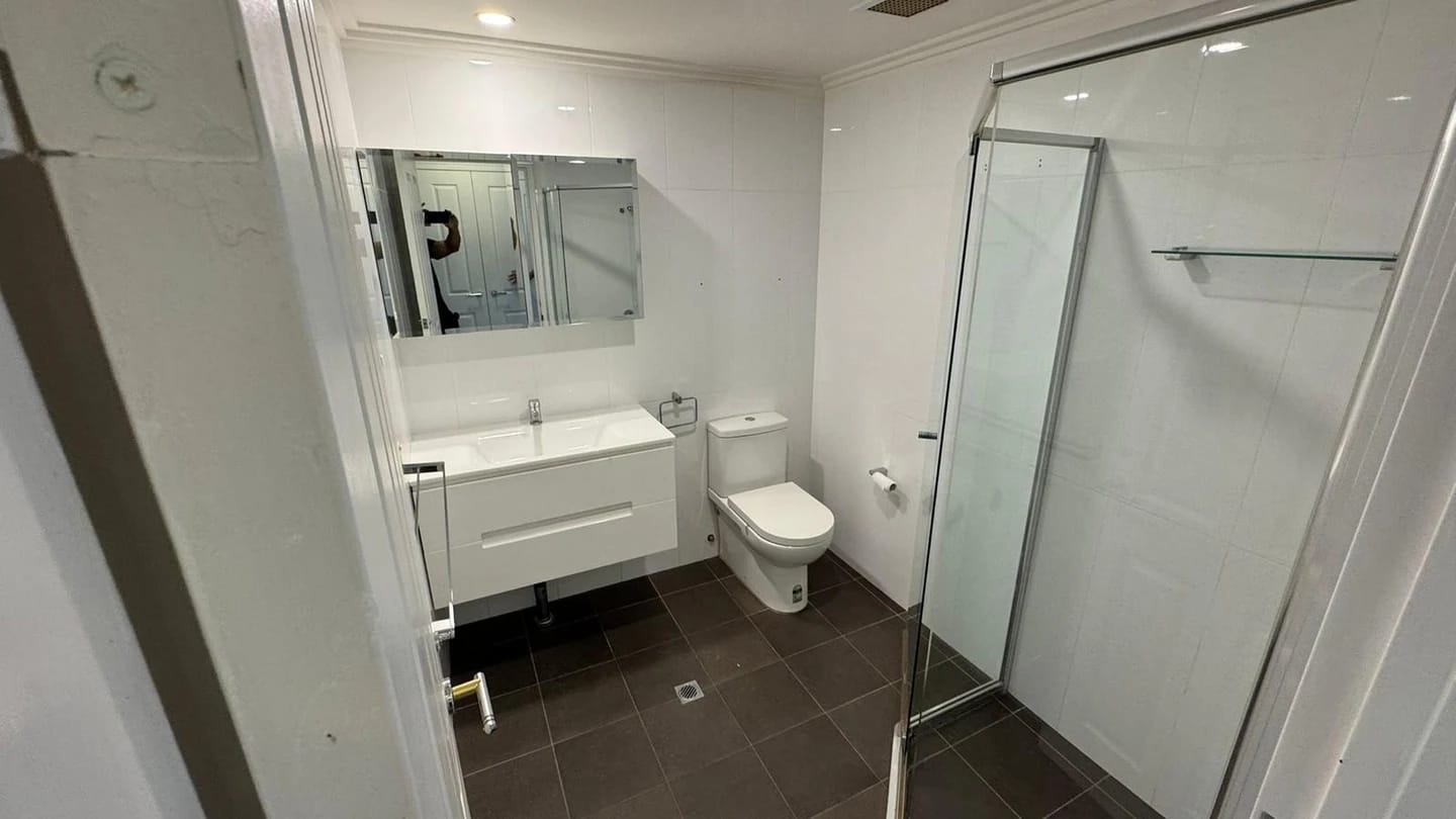 Apartment bathroom with vanity, toilet and shower before strip out