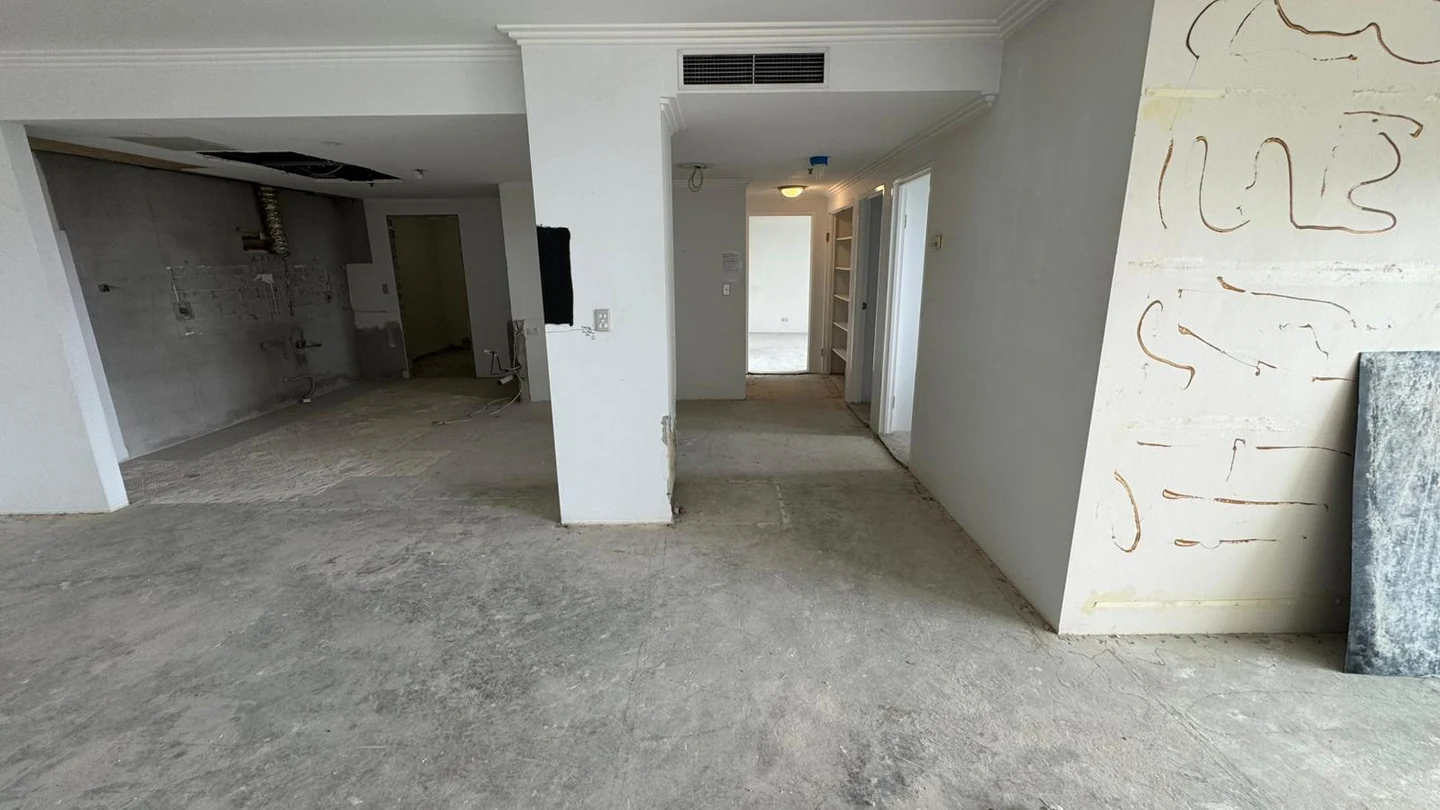 Apartment living and kitchen area after joinery and floor-finish removal