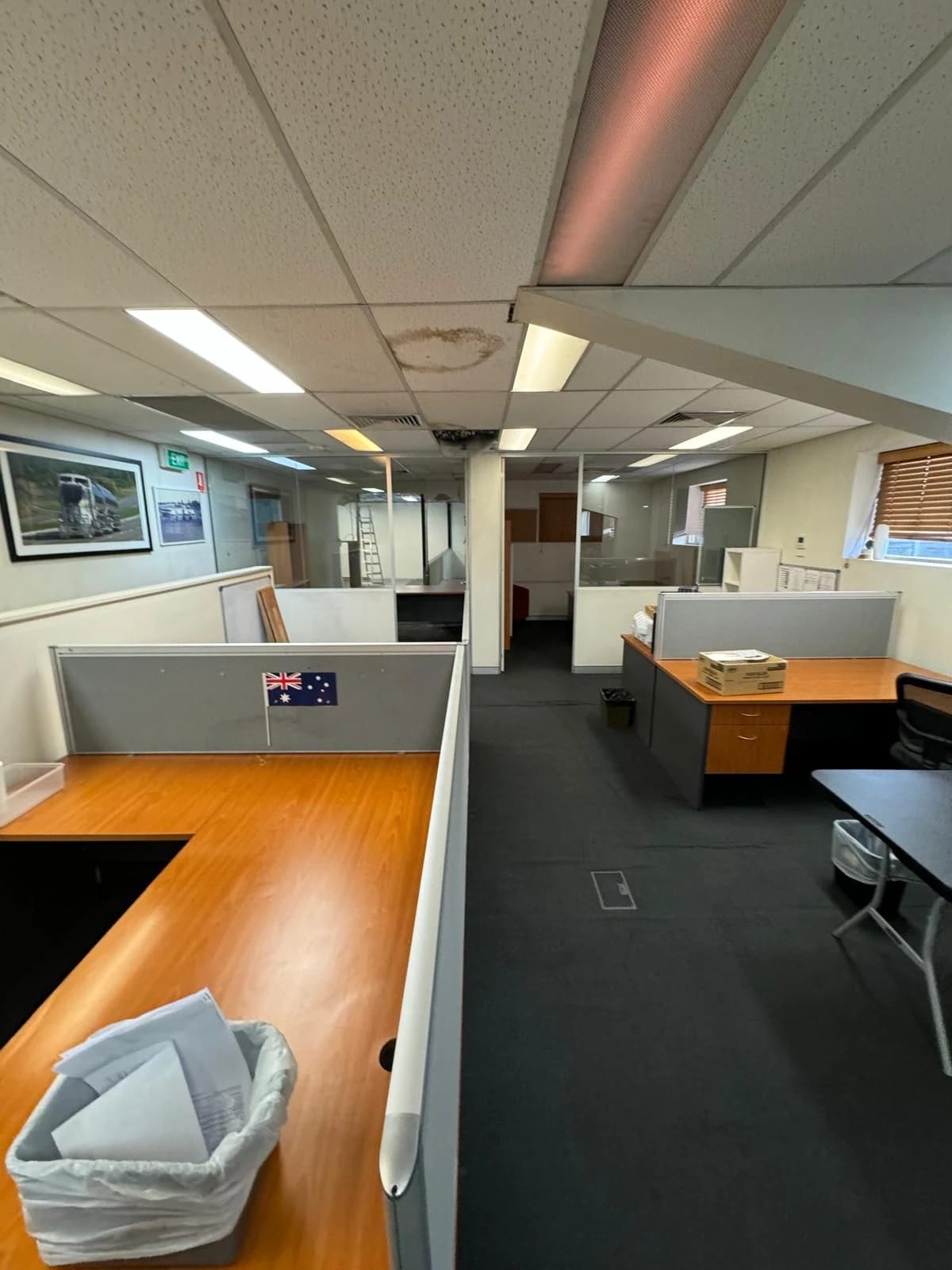 Open-plan office with workstations, floor covering and suspended ceiling before defit