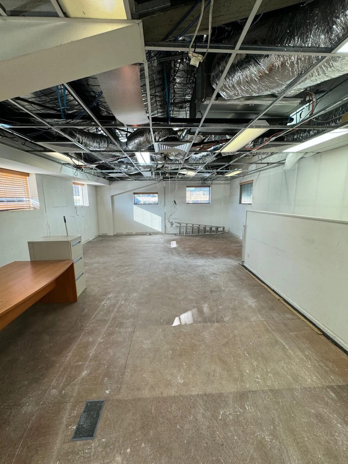 Open office area after partitions, workstations and ceiling tiles were removed