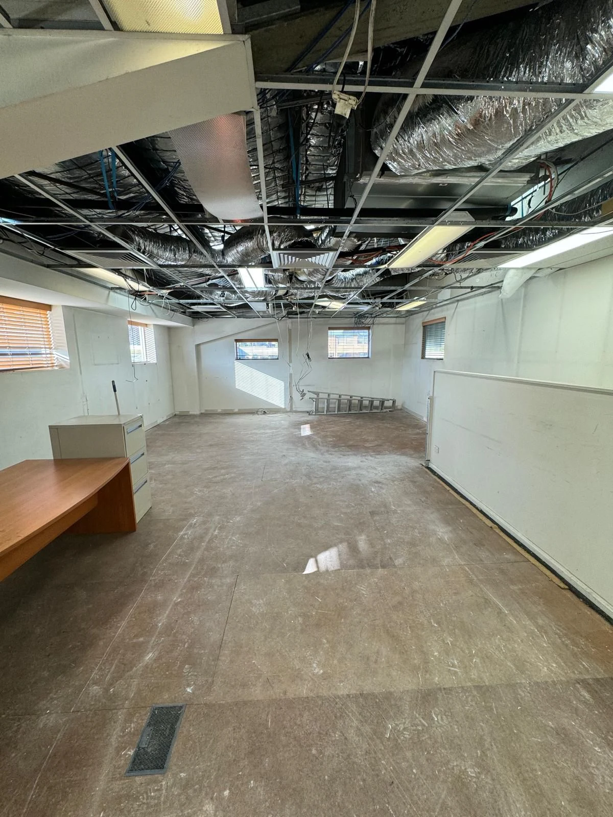 Open office area after partitions, workstations and ceiling tiles were removed