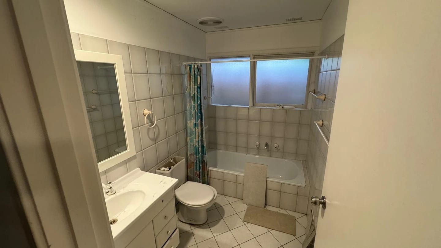 Tiled apartment bathroom before fixture and finish removal
