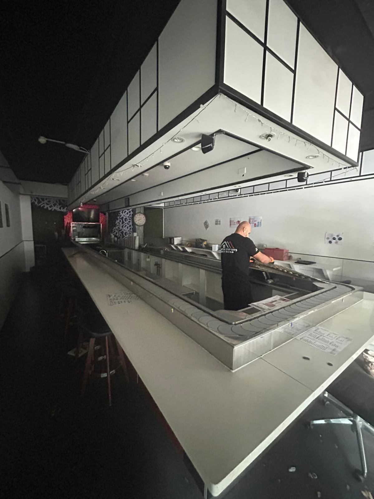 Crew member dismantling stainless service joinery inside the Mona Vale tenancy