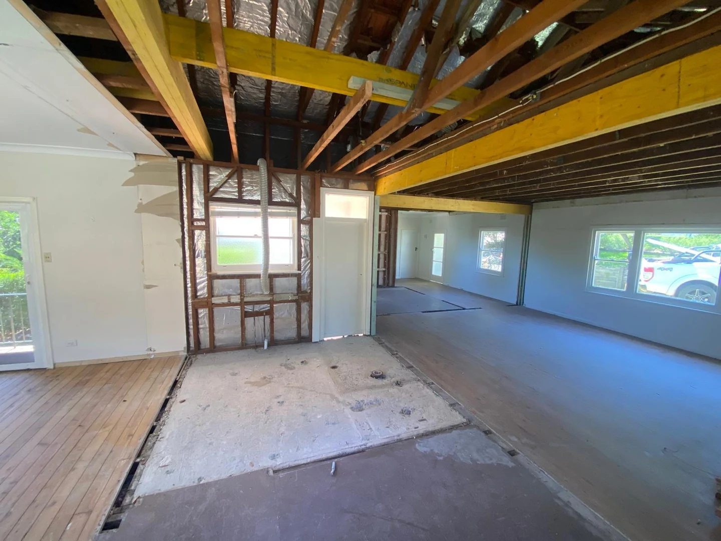 Open residential interior after partition removal and beam installation