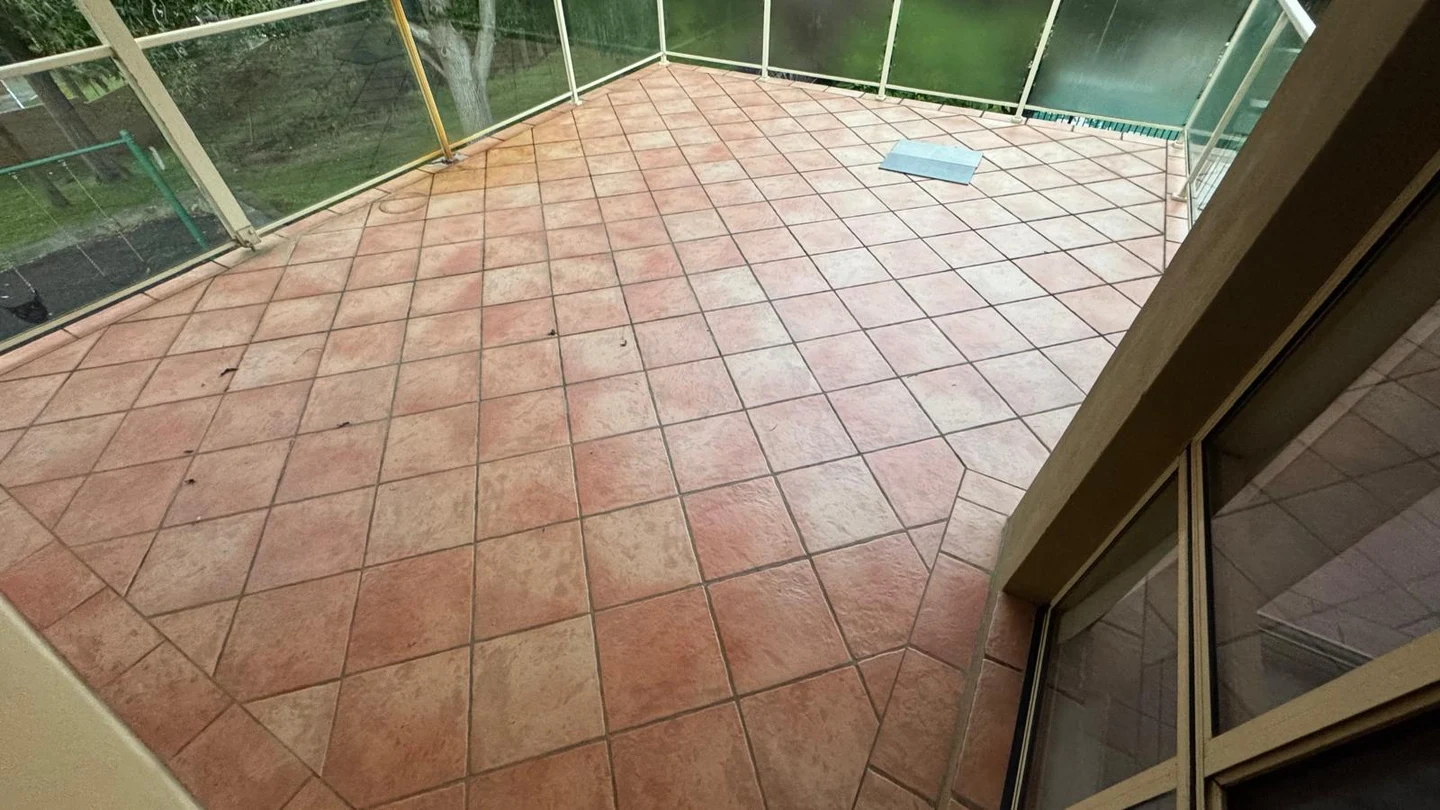 Tiled residential balcony before the damaged finishes were stripped