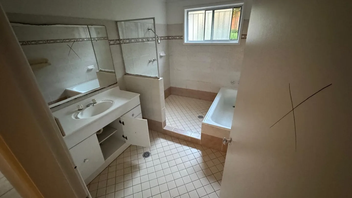 Bathroom before strip out with crosses marked on the mirror and door showing what is scheduled for removal