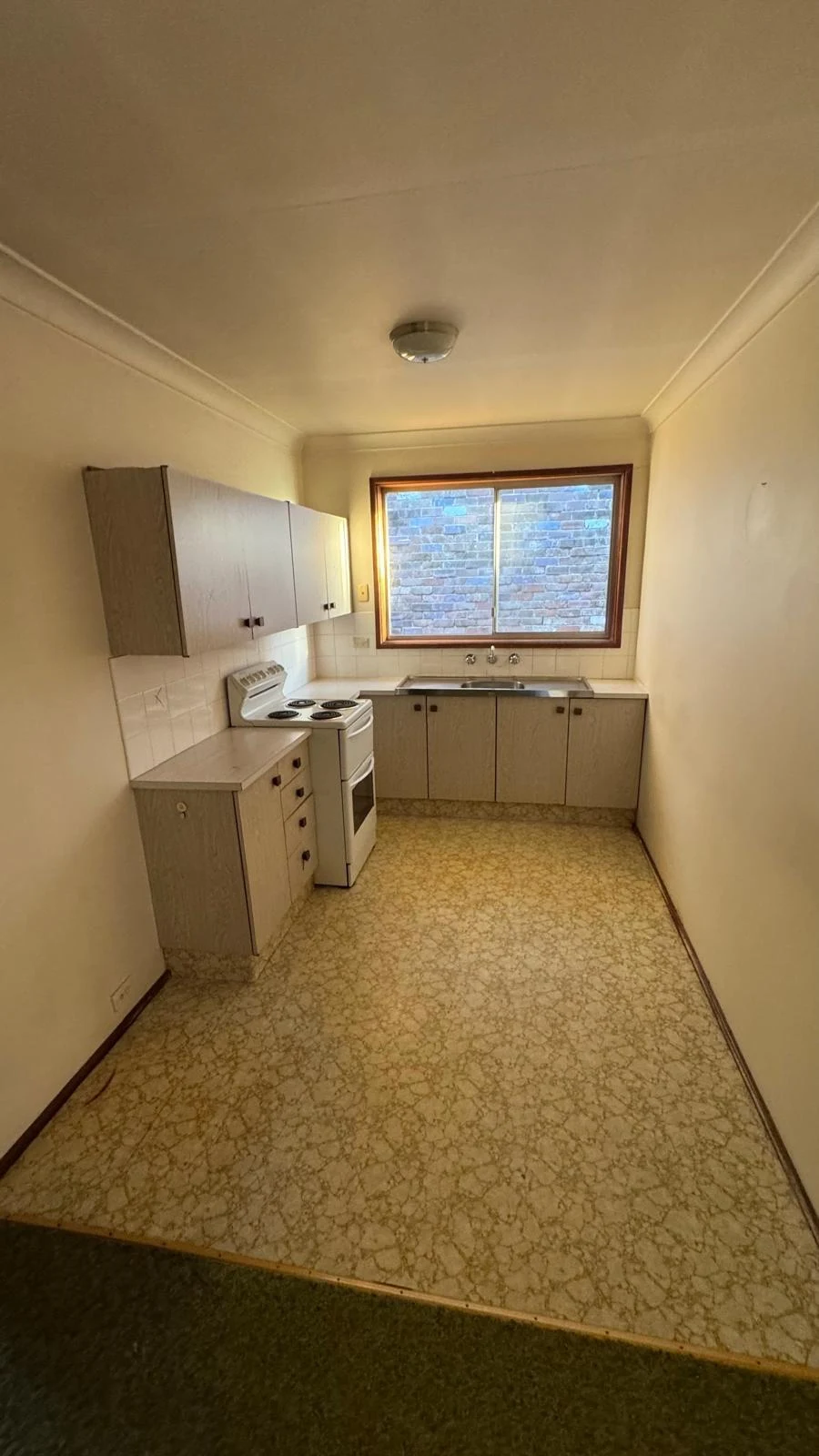 Compact galley kitchen before cabinetry and appliance removal