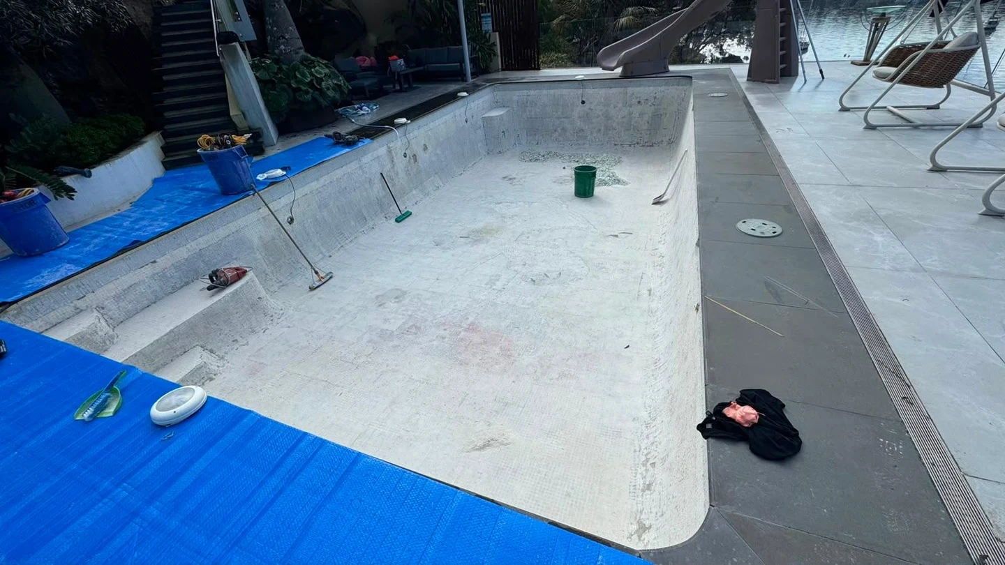 Residential pool shell after the pale mosaic interior finish was stripped away