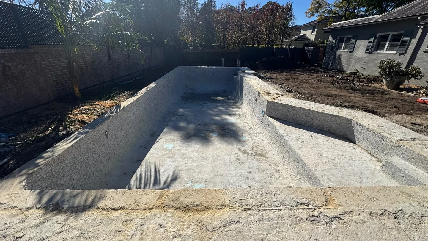 Residential pool shell after the blue interior surface was stripped from the floor and walls