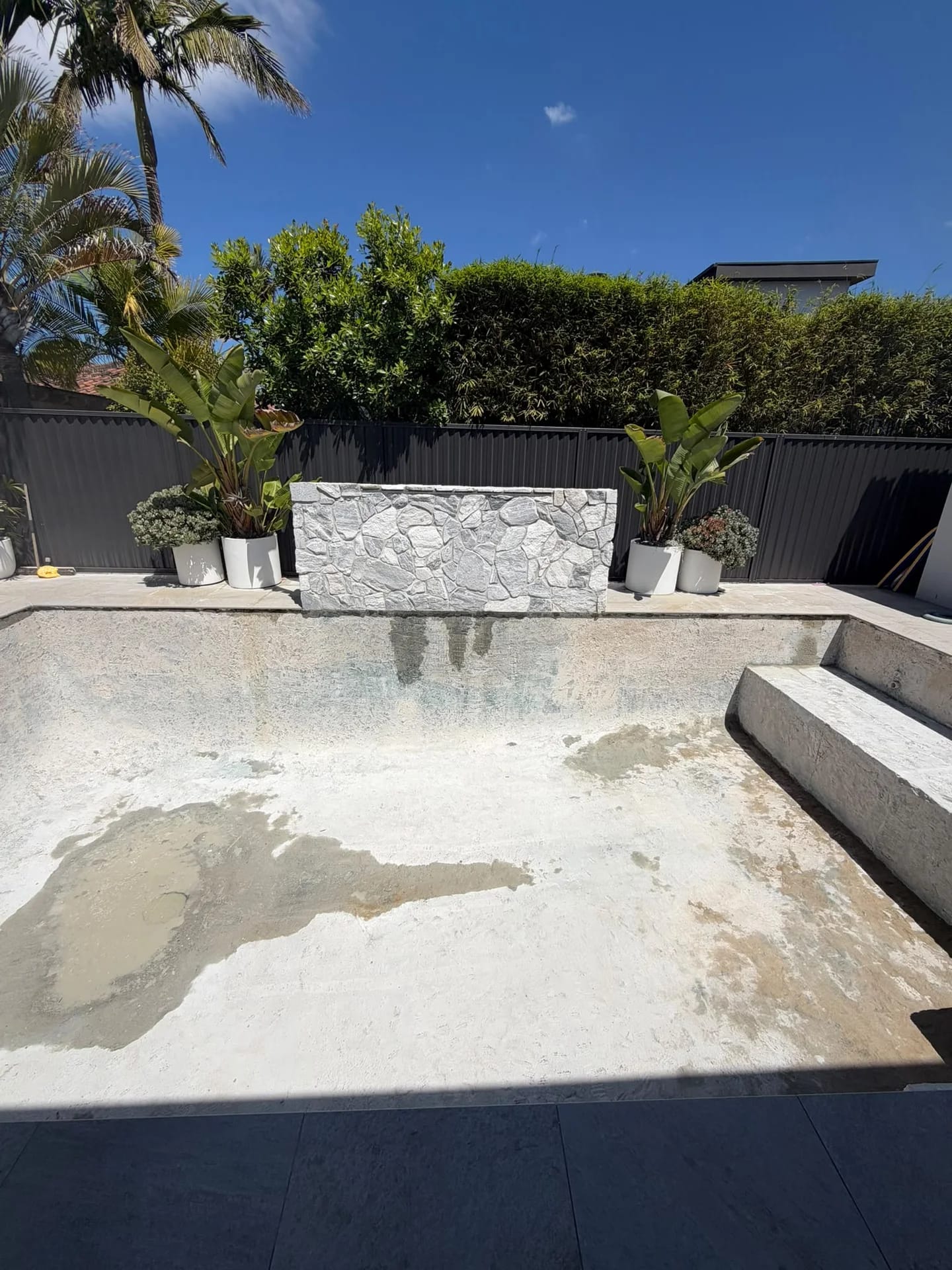 Sylvania Waters pool after mosaic tile removal, with the stone water feature and coping retained
