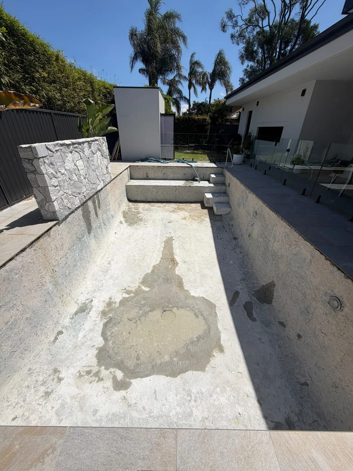 Pool floor, walls, steps and bench after blue mosaic tile removal in Sylvania Waters
