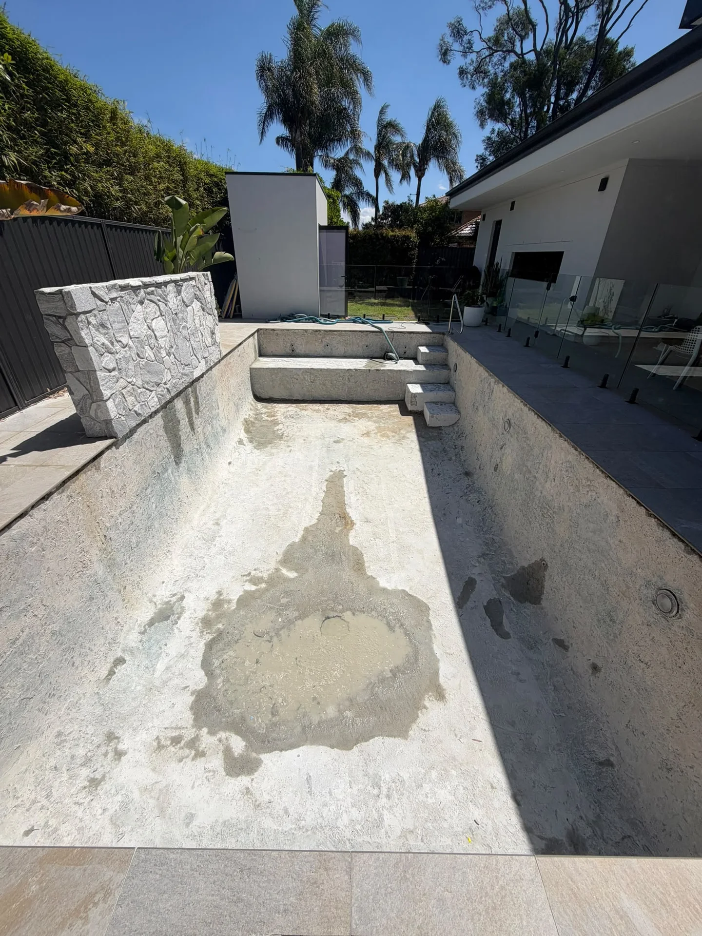 Pool floor, walls, steps and bench after blue mosaic tile removal in Sylvania Waters
