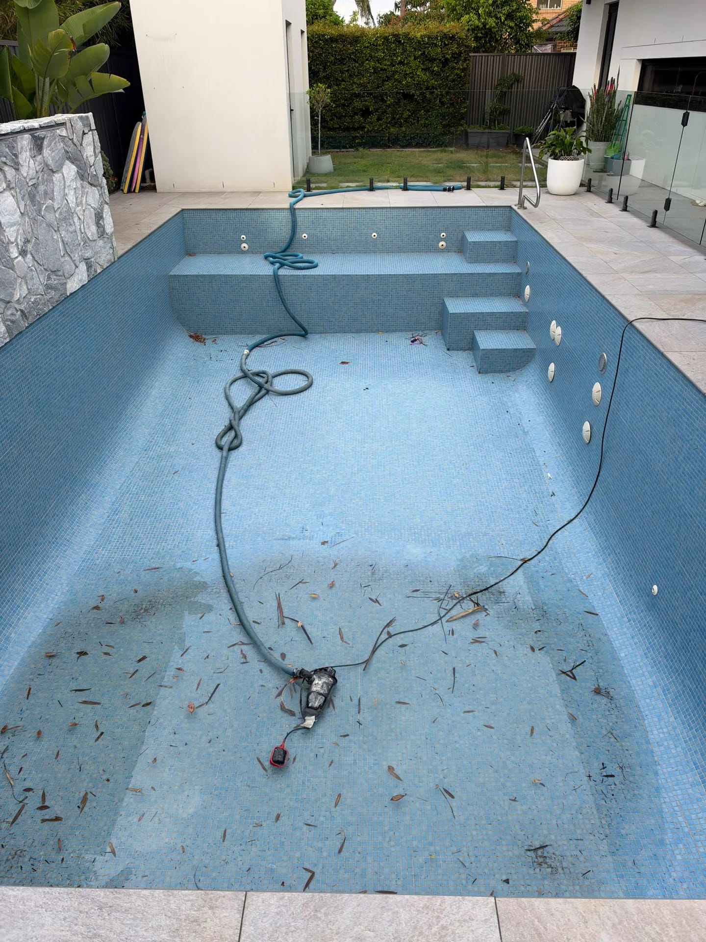 Blue mosaic pool tiles covering the floor, walls, steps and bench before the Sylvania Waters strip out